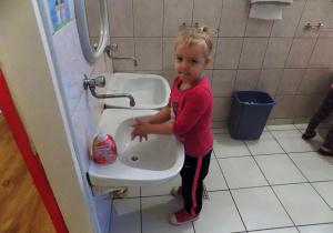 Nikola ćwiczy prawidłowe mycie rąk przy umywalce.